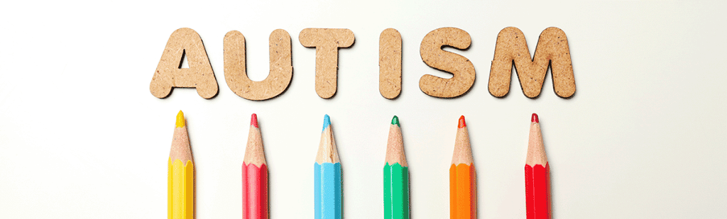 multicolored pencils with the word autism on a cream background on a page about dysgraphia dyspraxia and autism